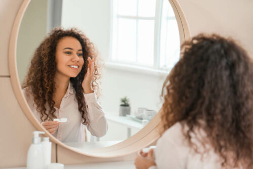young woman putting in contacts