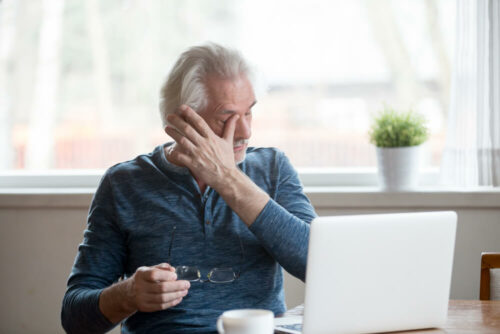 Older man rubbing his eyes