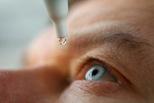 man getting drops in eyes