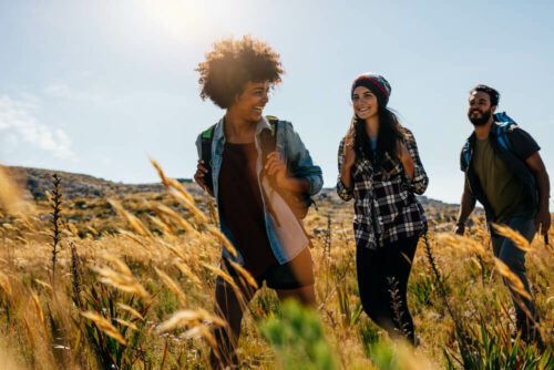 Young adults hiking through field