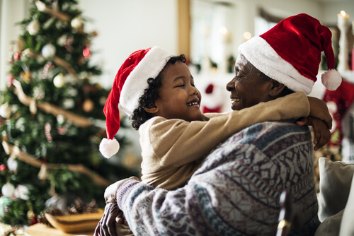 Kid hugging male family member at Christmas time